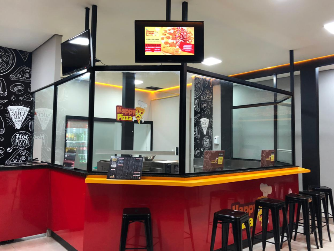 Interior e balcão de atendimento da Happy Pizza em Araguari